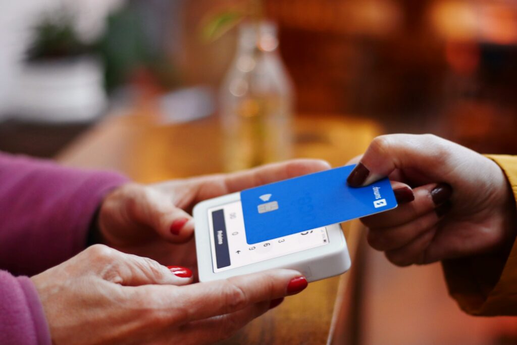 a person holding a credit card and a cell phone